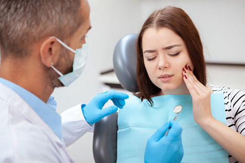 Woman in dental chair receiving treatment from dentist.
