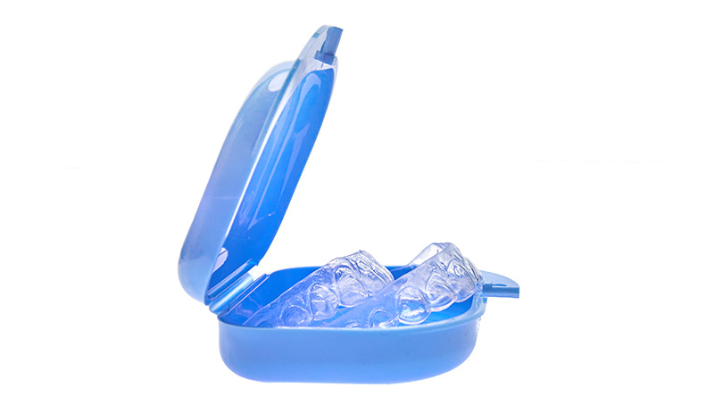 An image of a blue electric toothbrush with its head partially removed, revealing clear bristles and a transparent handle.